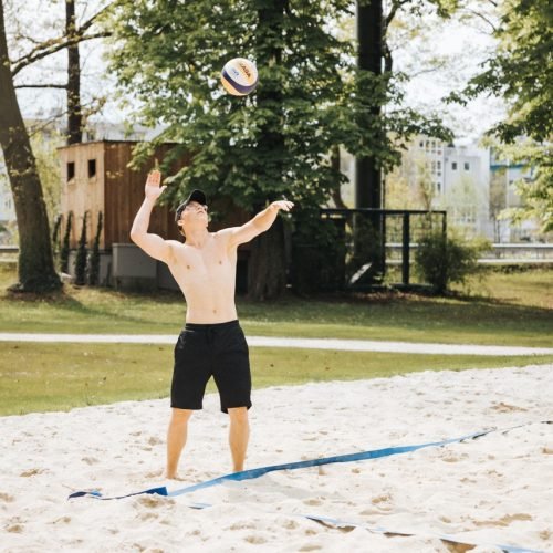 Junger Mann spielt Volleyball im Volksgarten